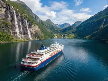 Rejs statkiem "Norwegian Fjord Explorer" przez malownicze fiordy Norwegii, z wodospadami i zielonymi zboczami.