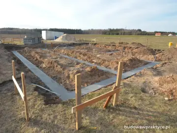 Rozpoczęto wylewanie fundamentu pod nowy dom. Wykopano rowy, w których widać świeży beton.