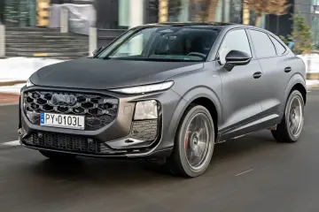 Matowy, ciemnoszary q3 audi pędzi po drodze, jego reflektory LED świecą jasno.