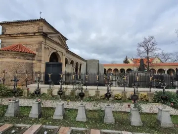 Wyszehrad: cmentarz z rzędami krzyży i arkadowymi budynkami.