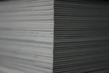 Stos kartek papieru, tworzący ostry kant. Zastanawiasz się, ile to ryza?