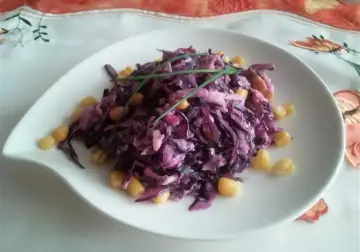 Wykwintna surówka z czerwonej kapusty z kukurydzą, niczym z restauracji, udekorowana szczypiorkiem.