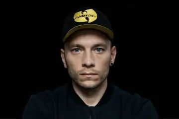 Młody mężczyzna w czapce z daszkiem Wu-Tang Clan, jeden z aktorów "Ślepnąc od świateł", patrzy prosto w obiektyw.