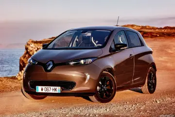 Brązowy Renault Zoe na tle morza i klifów. Poznaj jego renault zoe dane techniczne.