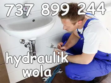 Hydraulik w Stalowej Woli przy umywalce, notuje coś na kartce. Telefon: 737 899 244.