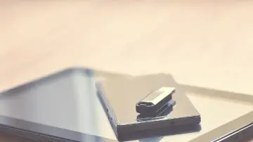 Pendrive leży na smartfonie, gotowy do podłączenia. Dowiedz się, jak podłączyć pendrive do telefonu, by przenieść dane.