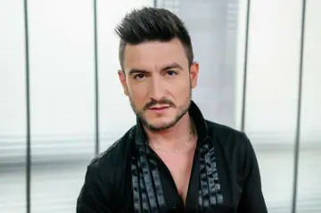 Michał Kwiatkowski, piosenkarz, w wieku około 30 lat, w czarnej koszuli.
