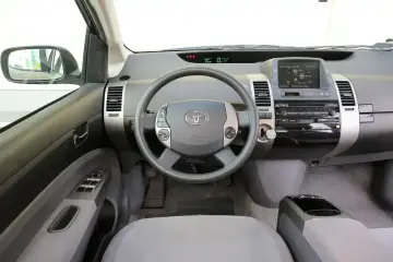 Wnętrze toyoty prius 2. Kierownica z przyciskami, ekran multimedialny i panel radia.