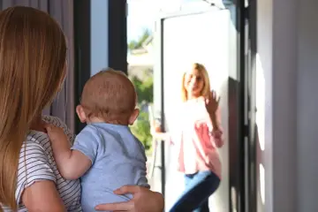Mama z dzieckiem wita nianię w drzwiach. Zastanawiasz się, ile zarabia niania miesięcznie?