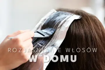 Dłoń z pędzlem nakłada rozjaśniacz na ciemne włosy owinięte folią. Dowiedz się, jak rozjaśnić włosy o 1-2 tony w domu.