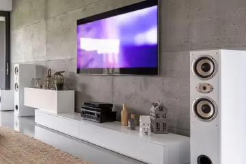 Nowoczesny salon z telewizorem, głośnikami i sprzętem RTV. Dowiedz się, jak podłączyć kino domowe do telewizora i dekodera, by cieszyć się kinowymi wrażeniami.