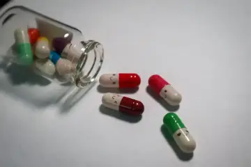 Kapsułki leków antydepresyjnych z uśmiechniętymi buźkami, niektóre wypadły z butelki. Czy wpływają na wyniki krwi?