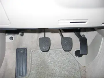 Wymiana pompy sprzęgła Volvo V50: widok na pedały sprzęgła, hamulca i gazu.
