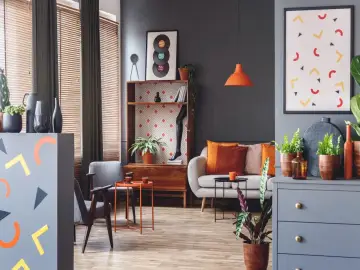 Nowoczesny salon z kanapą, fotelami i dekoracjami w kolorze morelowym.