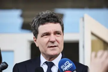 Prezydent Rumunii w garniturze odpowiada na pytania dziennikarzy, mikrofon Euro News w kadrze.