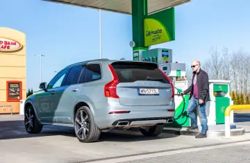 Mężczyzna tankuje szare Volvo XC60. Zastanawiasz się, ile spala Volvo XC60? Sprawdźmy!