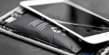 Widoczny spuchnięty akumulator iPhone, który wypycha ekran. To niebezpieczne zjawisko, które wymaga natychmiastowej wymiany.