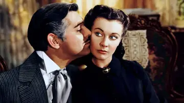 Rhett Butler szepcze coś Scarlett O'Hara. Ikoniczna scena z obsadą "Przeminęło z wiatrem".