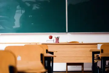 Pusta klasa z ławkami i zieloną tablicą. Na biurku jabłko i ołówki. Czy ocene roczna mozna zmienic?
