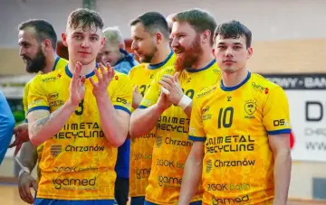 Drużyna MTS Chrzanów w żółtych koszulkach z numerami 3 i 10. Zawodnicy klaszczą, świętując zwycięstwo.