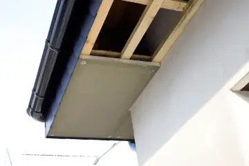 Drewniany stelaż podbitki dachowej, widoczny pod czarnym rynna, gotowy do montażu.