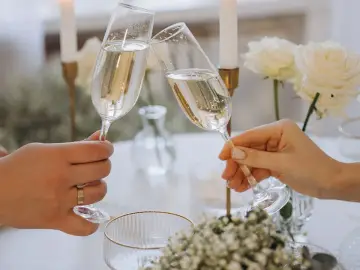 Wznoszenie toastu szampanem. Jakie są zasady serwowania alkoholu na weselu? Wino, wódka czy whisky – wybór należy do pary młodej.