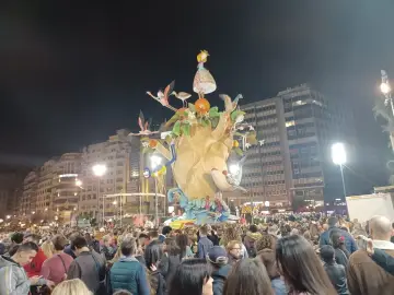 La foule admire une immense sculpture colorée, une scène typique du déroulement des Fallas de Valencia, avec des flamants roses et une petite fille perchée en haut.