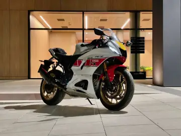 Sportowy motocykl Yamaha R7 w białym malowaniu z czerwonymi i żółtymi akcentami. Dane techniczne tego modelu są imponujące.