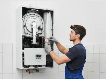 Tecnico controlla la pressione caldaia a 2 bar con manometro.