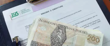 Wniosek o emeryturę ZUS z banknotami 200 zł. Dokumenty i pieniądze sugerują ponowne przeliczenie emerytury ze względu na długość życia.