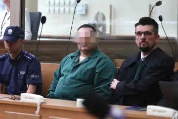 Oskarżony w zielonej koszuli, policjant i prawnik w togach. Czy rozprawa może się odbyć bez oskarżonego?
