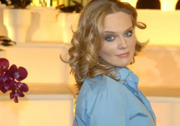 Maria Wiktoria Wałęsa w błękitnej koszuli, z kręconymi blond włosami i niebieskimi oczami, patrzy przez ramię.