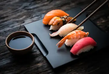 Zestaw sushi z łososiem, krewetką i tuńczykiem, gotowy do zanurzenia w sosie shoyu.
