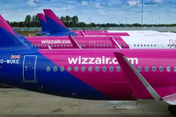 Różowe samoloty Wizzair stojące obok siebie. Może to być widok z lotniska, gdy planujesz wizzair zwrot biletu.
