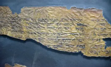 Fragmentary zwoje z Qumran, starożytne teksty pisane hebrajskimi literami na pożółkłym papirusie, ukazujące wieki historii.