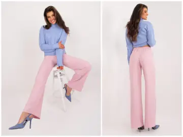 Modelka w pudrowym różu z czym łączyć stylizacje. Szerokie spodnie i błękitny sweterek tworzą elegancki zestaw.
