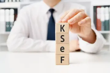 Dłoń układa kostki z literami K, S, E, F. To klucz do tego, jak sprawdzić ilość pracowników w firmie.