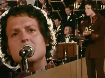 Kto śpiewał "Zegarmistrz światła purpurowy"? To on, z mikrofonem i gitarą, na tle orkiestry.
