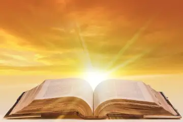 Otwarta księga, z której wydobywa się światło, symbolizuje wiarę, która zwycięża świat.