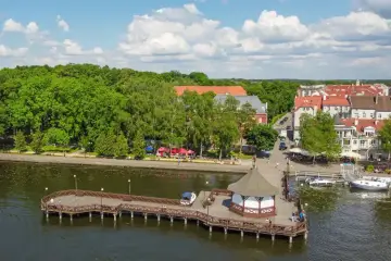 Malownicze miasteczko nad jeziorem, idealne na tani weekend z dziećmi. Drewniane molo, zielone drzewa i urokliwe kamienice.