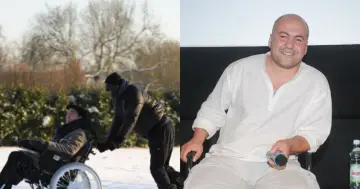 Dwóch aktorów z obsady filmu "Nietykalni" - jeden pcha wózek inwalidzki na śniegu, drugi siedzi na krześle z mikrofonem.