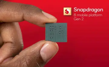 Palec i kciuk trzymają niewielki procesor. Obok widnieje logo Snapdragon 8 mobile platform Gen 2.