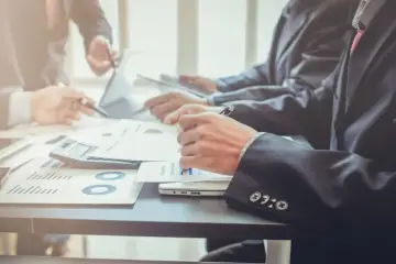 Prezes zarządu analizuje wykresy i notuje.