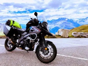 Szary Suzuki V-Strom, najlepszy motocykl turystyczny, gotowy na przygodę wśród alpejskich szczytów.