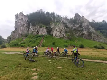 Grupa rowerzystów na tle skalnych ostańców. Jura Krakowsko-Częstochowska rowerem to wspaniała przygoda.