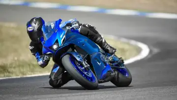 Motocyklista pochyla się na torze na niebieskim motocyklu Yamaha R7. Poznaj jego yamaha r7 dane techniczne.