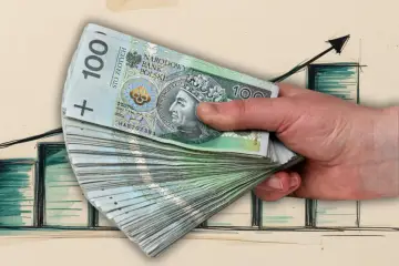 Dłoń trzyma stos banknotów 100 zł na tle wykresu wzrostu. Czy to zapowiedź wyższego średniego wynagrodzenia?