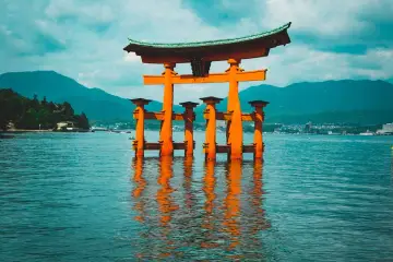 Wielka, pomarańczowa brama torii w morzu, zapytaj siebie, ile kosztuje wycieczka do Japonii, by zobaczyć ten widok.