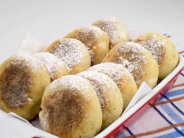 Proziaki Siostry Anastazji, puszyste i lekko zarumienione, posypane cukrem pudrem, czekają w czerwonej misie.