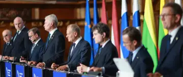 Liderzy państw stojący za mównicami, na tle flag narodowych i UE. W tle widoczna jest nazwa "Eastern Flank Summit", sugerująca spotkanie w ramach koalicji europejskiej.